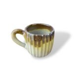 Nile Artisan handmade ceramic mug with earthy brown and beige vertical ribbed glaze.