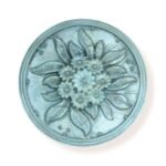 Round floral decorative wall piece with intricate flower and leaf design in a soft blue finish.