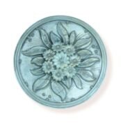 Round floral decorative wall piece with intricate flower and leaf design in a soft blue finish.