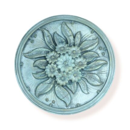 Round floral decorative wall piece with intricate flower and leaf design in a soft blue finish.