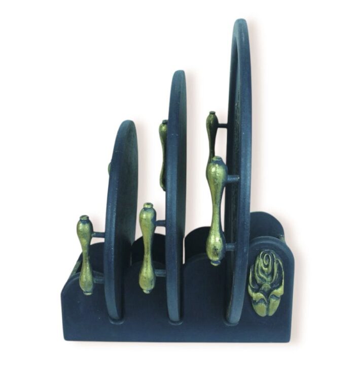 Dark blue wooden tray holder with golden-handled trays, side view.