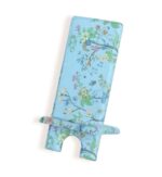 Decorative phone stand with light blue background and floral pattern featuring green leaves and colorful flowers