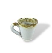 Purity Heritage handmade ceramic mug with white glaze and golden drip effect.
