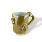 Pharaoh’s Treasures handcrafted ceramic mug with embossed motifs and glossy golden glaze.