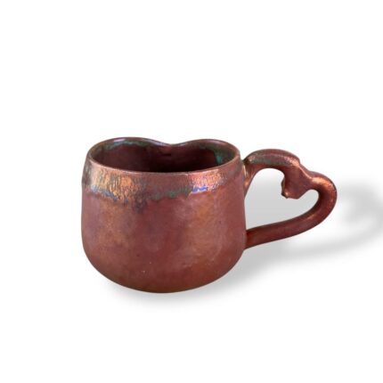 Heart-shaped ceramic mug by Creativity Al-Mahrousa – handcrafted pottery in deep red glaze.
