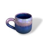 Handcrafted ceramic mug with rich copper, teal, and cobalt blue glazes blending vertically with an earthy, aged texture.