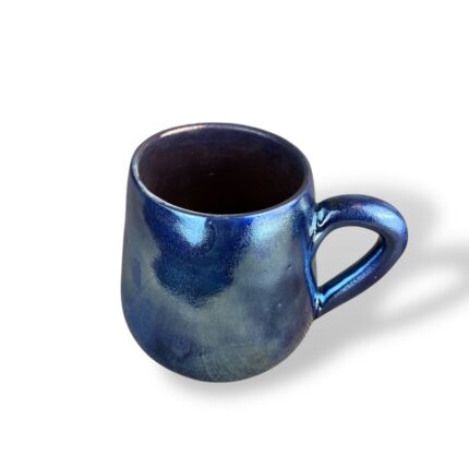 Glossy ceramic mug with a sleek, deep blue finish that reflects light like a shimmering ocean surface.