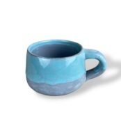 Handcrafted ceramic mug with a smooth blue and gray gradient, exuding elegance and serenity.