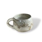 Handcrafted ceramic mug with a textured, sandy beige finish, exuding warmth and natural elegance.