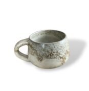 Handcrafted ceramic mug with a textured, sandy beige finish, exuding warmth and natural elegance.