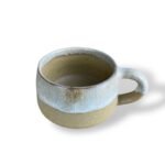 Handcrafted ceramic mug with a smooth white and beige gradient