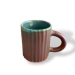 Royal Clay ceramic cup with turquoise rim and textured brown body.