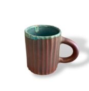 Royal Clay ceramic cup with turquoise rim and textured brown body.
