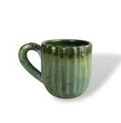 Green ceramic mug with a textured design and a curved handle, placed on a white background.