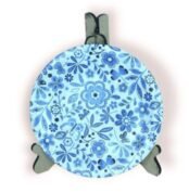 Round blue floral coaster displayed on a stand, featuring intricate flower and leaf patterns.