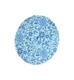 Round blue floral coaster showcasing intricate blue flower and leaf design, flat view under soft lighting.