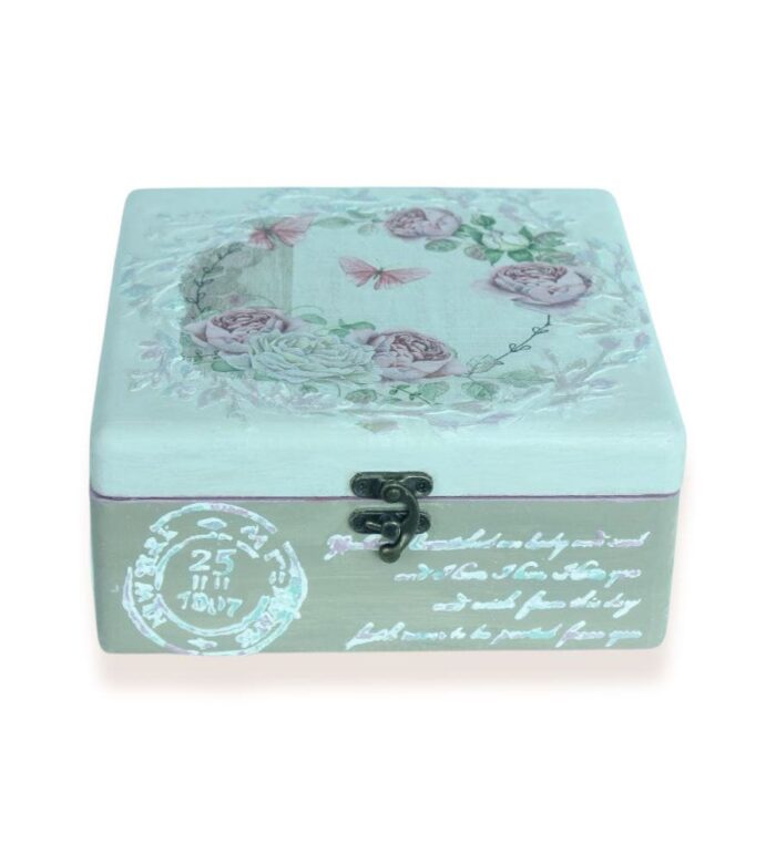 Closed decorative wooden box with floral lid design and handwritten script on the sides.