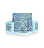Front view of decorative coaster set with vibrant geometric tile designs in a matching holder.
