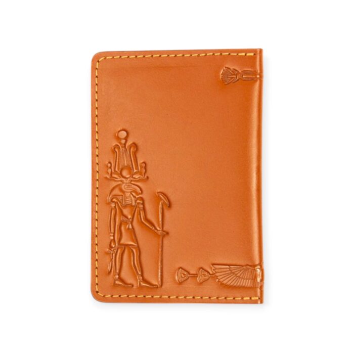 Closed view of a light Havana brown leather passport cover with embossed ancient Egyptian deity figures.