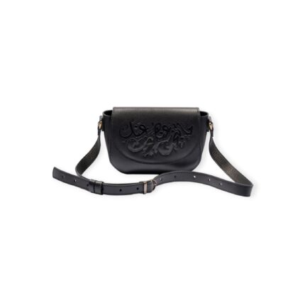 Front view of black small crossbody leather bag with Arabic calligraphy engraving on flap and adjustable strap.