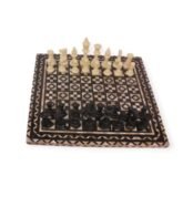 Top view of the Royal Chess Set with black and ivory pieces, showcasing the intricate inlay design of the board.
