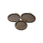 Three round handcrafted trays with intricate geometric patterns and gold handles arranged in a semi-circle.