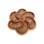 Top-down view of a wooden serving tray shaped like a six-petal flower with all compartments in place