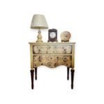 Vintage floral nightstand with decorative drawers and classic wooden legs.