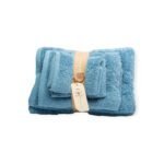 Folded blue cotton towel set tied with jute strap and wooden button, featuring Ghazy brand tag