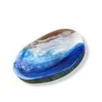 Side view of round wood resin centerpiece with ocean-inspired swirls.