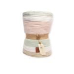 Rolled striped blanket with soft pastel layers in pink, green, beige, and white, tied with a jute strap and Ghazy tag