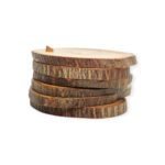 Stack of rustic wooden slices with bark edges, neatly aligned and topped with a small wooden peg