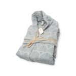 Folded light blue bathrobe with shell-patterned texture, tied with jute string and Ghazy brand tag