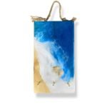 Vertical sea-inspired epoxy keyholder with beach wave design and seashells on wood.