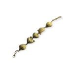 Gold-tone bracelet with leaf-shaped pod links on white background