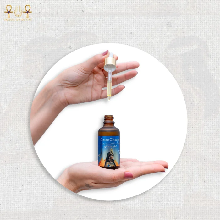 CairoCharm Hair Oil bottle with dropper, held in hand, showcasing the product.