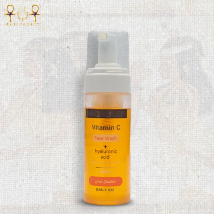 Vitamin C face wash with hyaluronic acid in a 150ml foam pump bottle, bright orange liquid, upright on textured background.