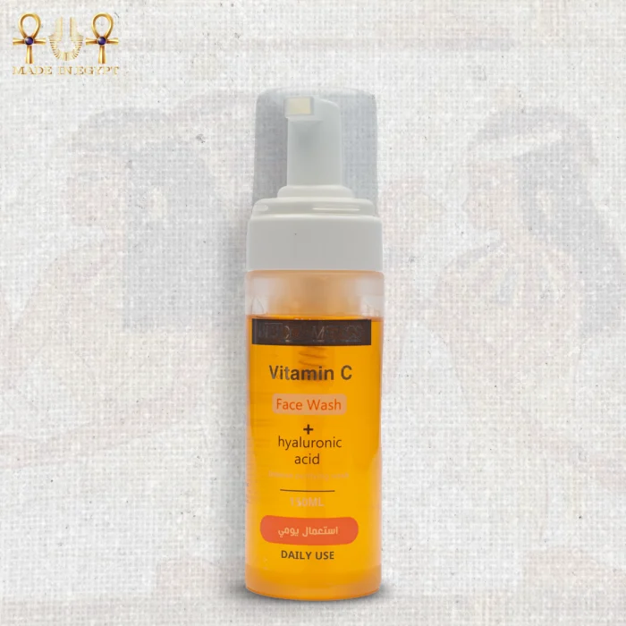 Vitamin C face wash with hyaluronic acid in a 150ml foam pump bottle, bright orange liquid, upright on textured background.