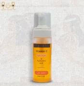 Vitamin C face wash with hyaluronic acid in a 150ml foam pump bottle, bright orange liquid, upright on textured background.