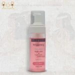 Whitening face wash bottle with kojic acid and hyaluronic acid, standing upright on a textured background.