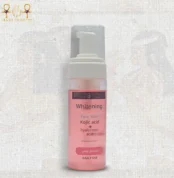 Whitening face wash bottle with kojic acid and hyaluronic acid, standing upright on a textured background.