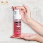 Whitening face wash with kojic acid and hyaluronic acid in a 150ml foam pump bottle, held in hands.