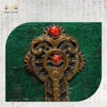 Close-up of ornamental antique key with red gemstone detail