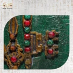 Close-up of antique key with red and green gemstone accents