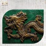 Detailed view of golden dragon motif on green wooden surface