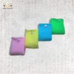 Close-up of four colorful Deep Exfoliating Towels in pink, yellow, blue, and green.