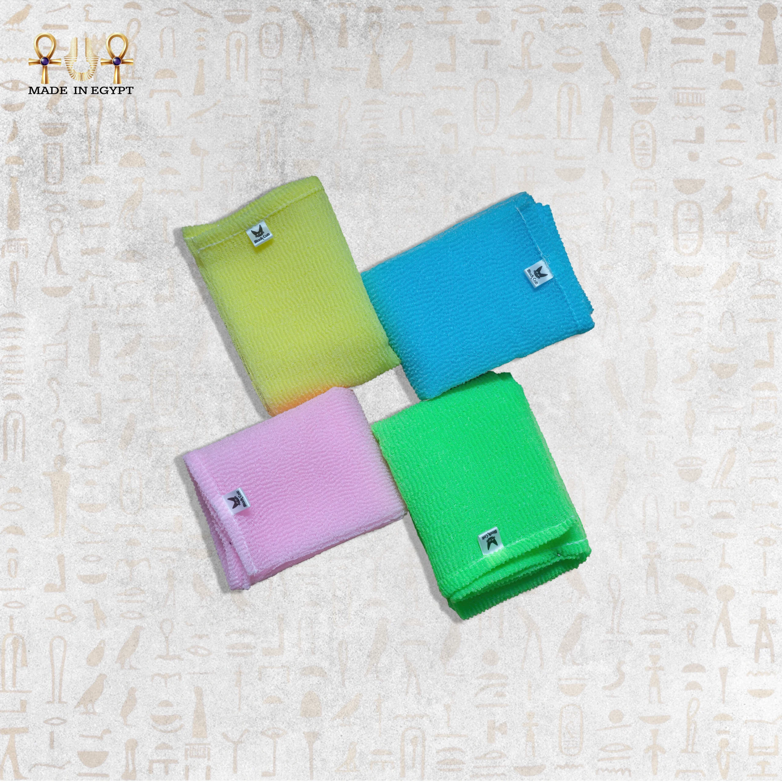 Deep Exfoliating Towels Stack – Vibrant Colors A stack of four Deep Exfoliating Towels in vibrant pastel colors – pink, yellow, blue, and green.