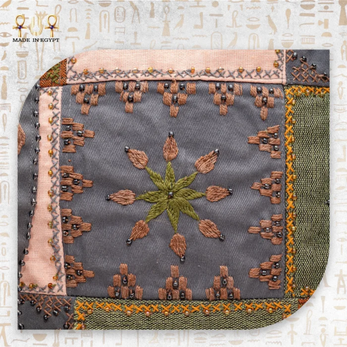 Close-up of intricate embroidery on the Flower Squares bag, highlighting the flower motif in orange, gray, and pink.