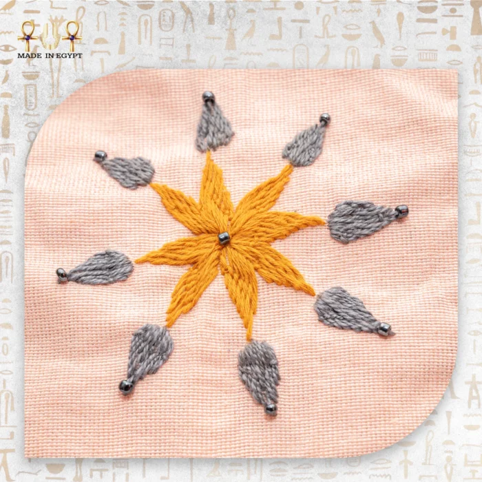 Detailed embroidery of a flower motif on the Flower Squares bag with shades of brown, green, and gray.