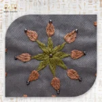Close-up of flower embroidery on Flower Squares bag, with bead accents and earthy color tones.